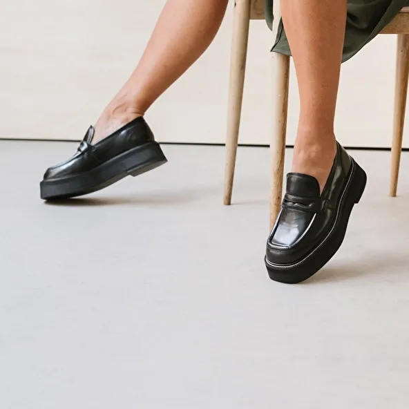 Platform loafers in black glazed leather