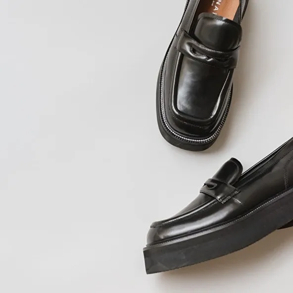 Platform loafers in black glazed leather